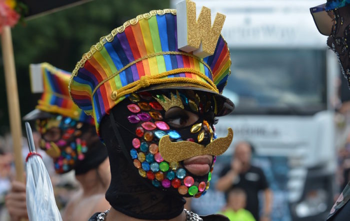 Happy masked man with rainbow hat
