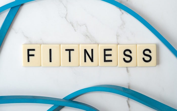 Fichas de Scrabble que forman la palabra 'Fitness' como parte de una rutina de gimnasio