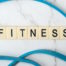 Scrabble tiles spelling 'Fitness' as part of a gym routine