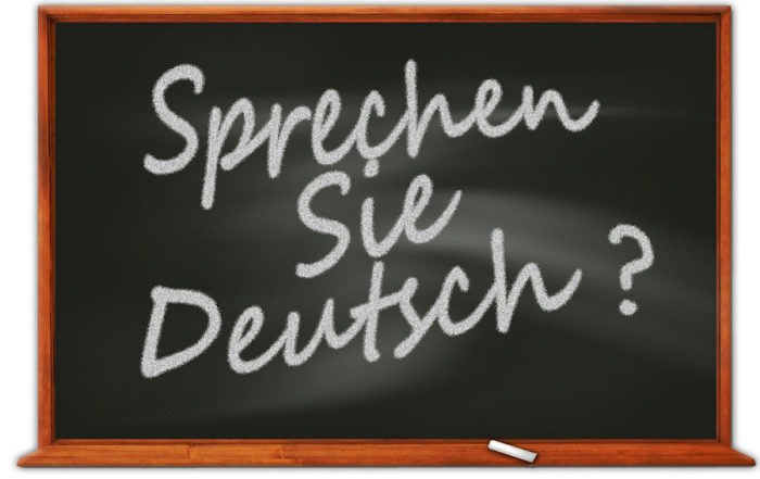 Deutsche Sprachreise - Tafel mit der Aufschrift „Sprechen Sie Deutsch?” in weißer Kreide, die Menschen einlädt, Deutsch zu lernen oder zu sprechen.