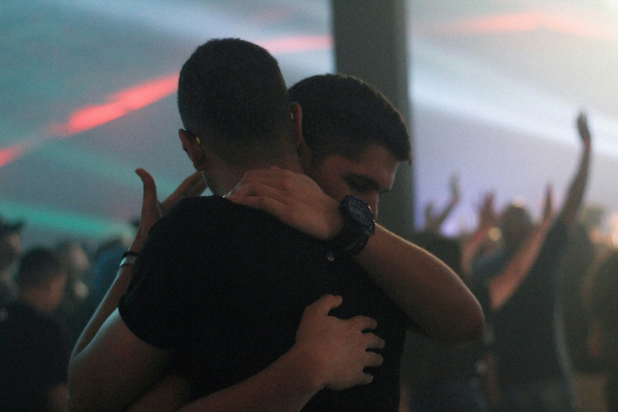 Amor Inocente: Dos hombres abrazándose en un momento emocional en un evento.