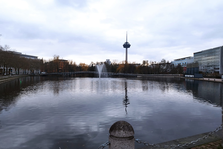 Media Park Seeblick, Colonius-Turm, Spiegelungen der Wasserfontäne, ruhige Atmosphäre, Verbindung von Stadt und Natur, Köln, Deutschland.