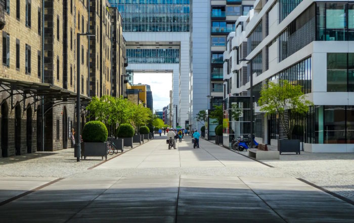 Tour trip in Cologne: A bustling city street with a prominent building in the background, showcasing urban life and architecture.