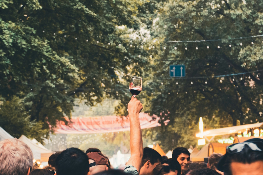 Weinfest: Un camarero sirve una copa de vino blanco en un evento al aire libre.