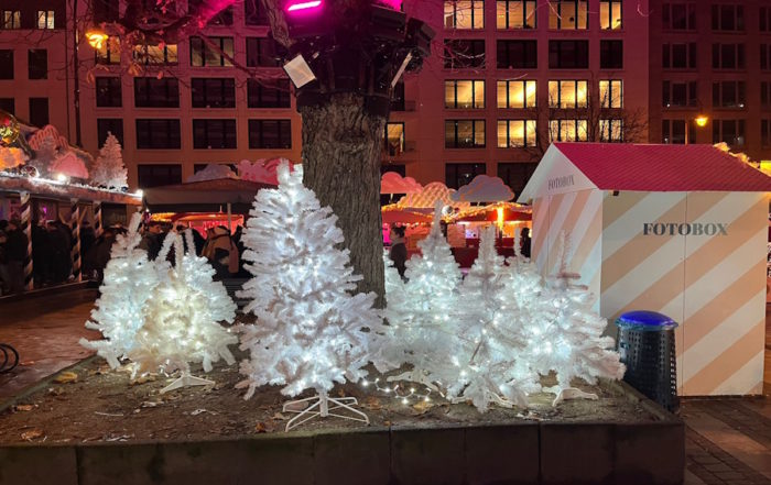 Heavenue Weihnachtsmarkt: Weiß Beleuchtete Weihnachtsbäume und Fotobox Fotokabine auf dem Kölner Winterfestival