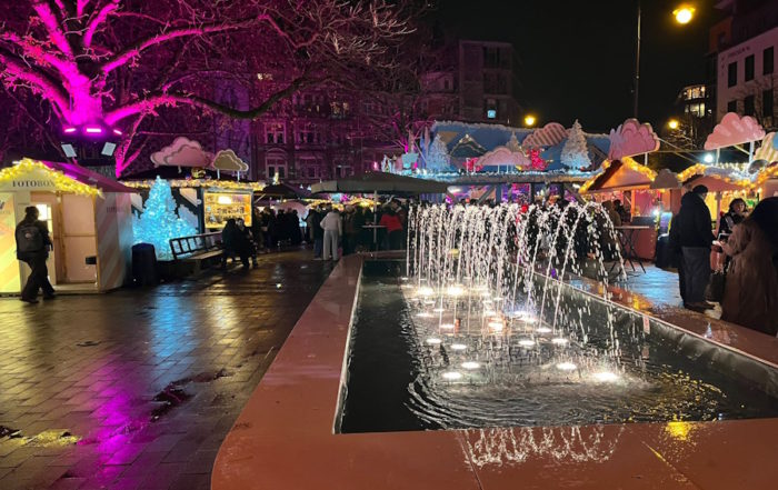 Heavenue Winterwunderland: Beleuchteter Springbrunnen und Weihnachtsmarkt-Dekorationen bei Nacht in Köln