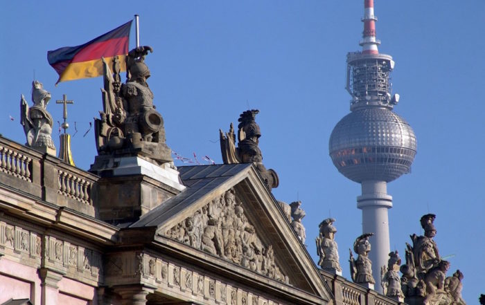 Home 12 Fernsehmetropole Berlin: Fernsehturm hinter historischem Gebäude mit deutscher Flagge